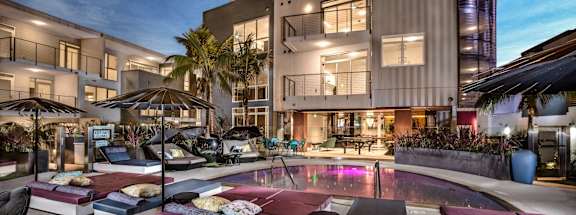 Vinz on Fairfax Apartments in Los Angeles, California Exterior and Pool with Lounge Chairs at Dusk