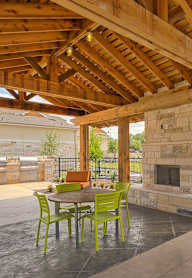 A patio with a fireplace and chairs.