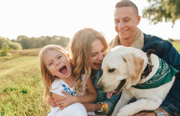 Family Smiling and Playing with Dog