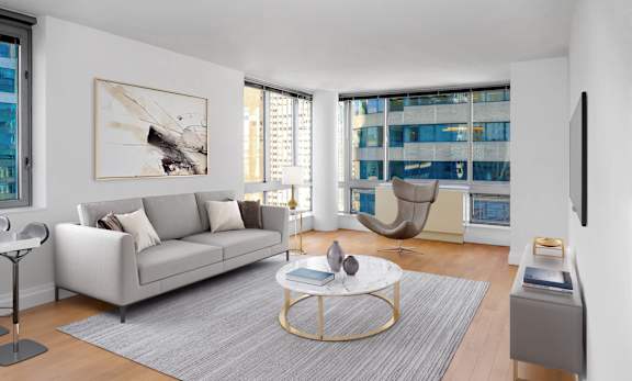 A modern living room with a grey sofa, a coffee table, and a large window.at 'The Metropolis', New York New York
