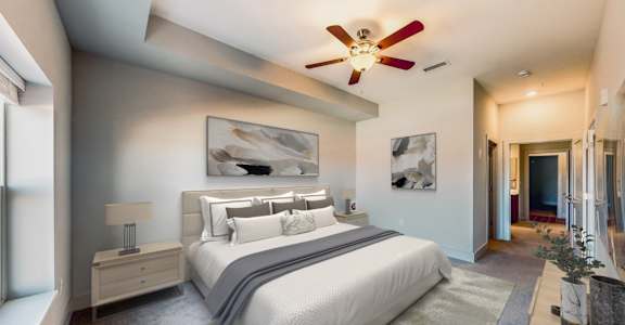 A bedroom with a large bed and a ceiling fan.
