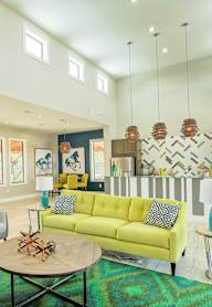 A living room with a yellow couch and a coffee table.
