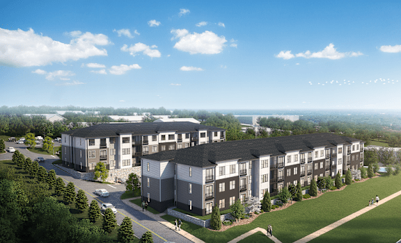 A large apartment complex with multiple buildings and a few cars parked outside.