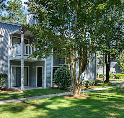 A house with a grey siding and a white porch.