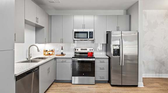 A modern kitchen with stainless steel appliances and white cabinets.