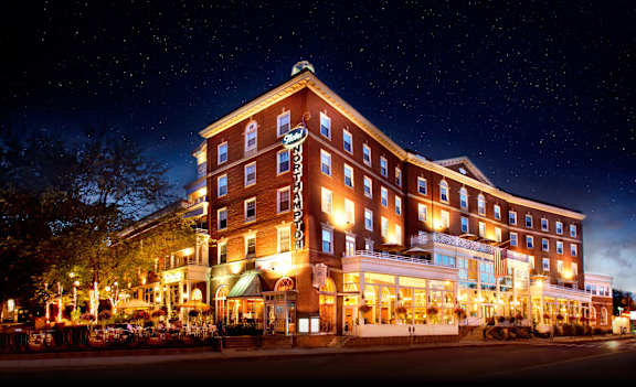 A large hotel with a lit up sign on the front.