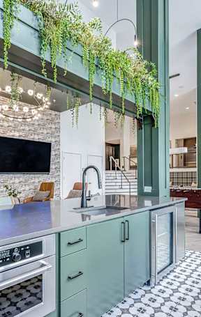 A modern kitchen with a white island and stainless steel appliances.
