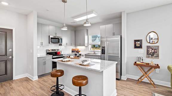A kitchen with a white island and a refrigerator.