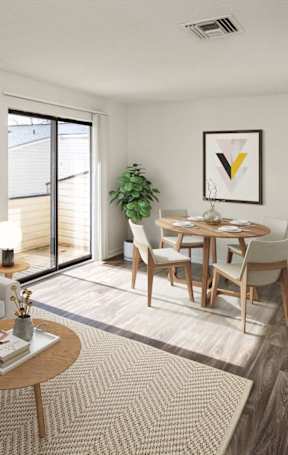 A living room with a white couch, a wooden coffee table, and a dining table with chairs.