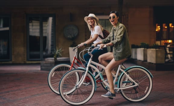 two women riding bikes on the street at The Waters at Chenal, Little Rock, Arkansas