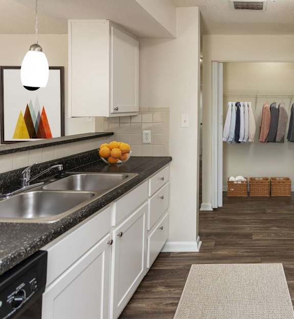 A kitchen with black appliances and white cabinets.