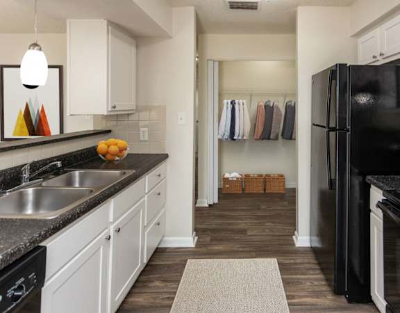 A kitchen with black appliances and white cabinets.