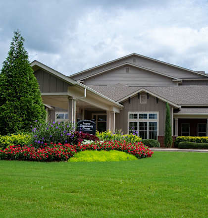 a large house with a lawn and flowers in front of it