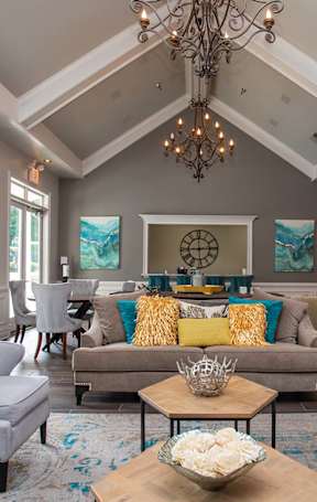 A living room with a chandelier, couches, and a coffee table.