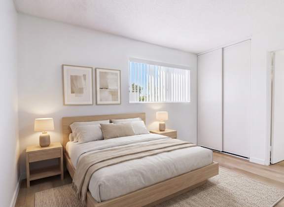A bedroom with a large bed and two nightstands.