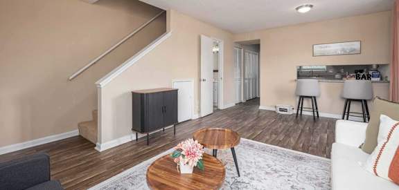 A living room with a staircase and a flat screen TV.