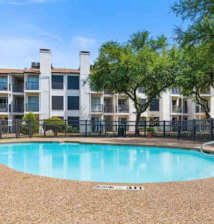 a swimming pool with an apartment building in the background