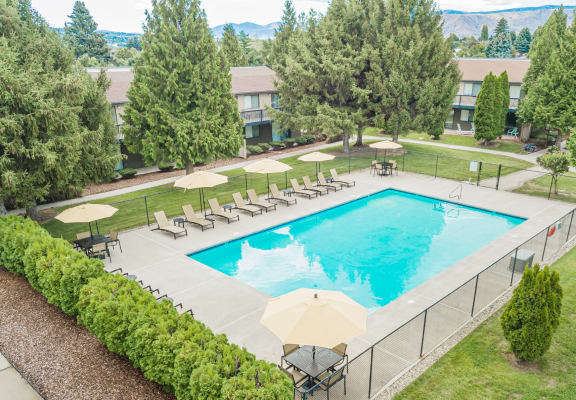 an aerial view of a swimming pool with chairs and umbrellas at Cedarwood, Wenatchee, WA