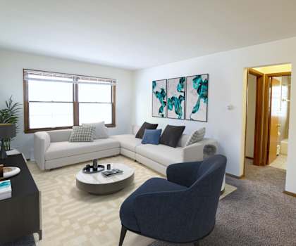 A living room with a grey armchair and a white sofa.