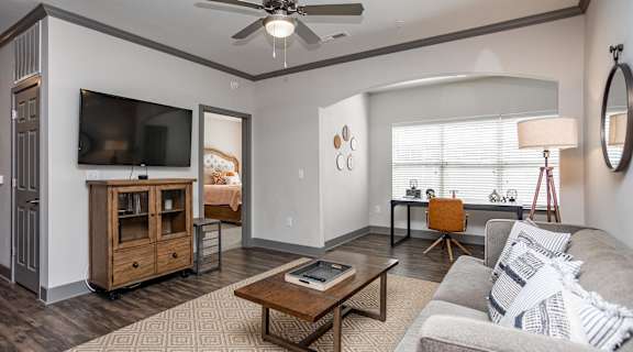 a living room with a ceiling fan and a tv