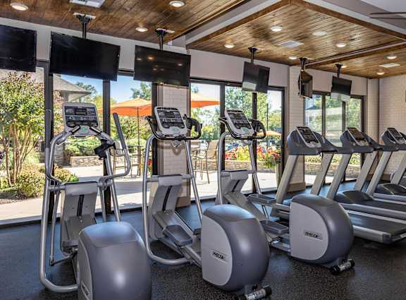 A gym with treadmills and elliptical machines.