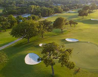 A golf course with green grass and white sand traps.