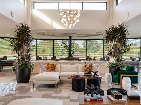 the lobby of a hotel with a couch and chairs and large windows at Esplanade District Apartments, Little Rock