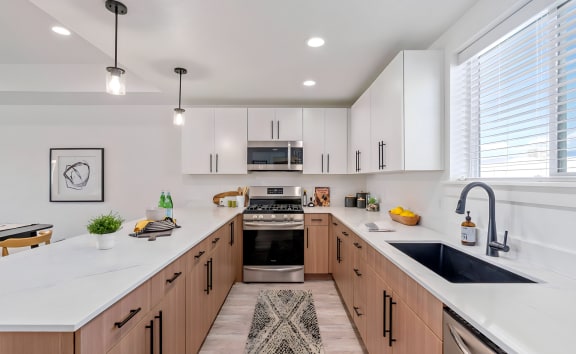 a large kitchen with white counter tops and wooden cabinets