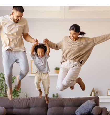 a family jumping on a couch in a living room