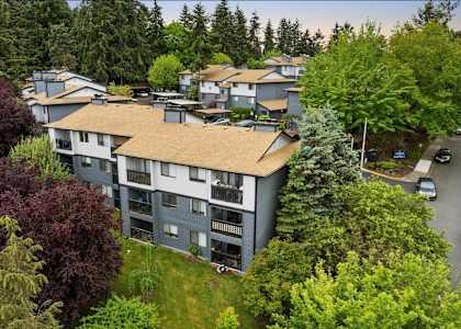 Apartment complex with green trees around it.
