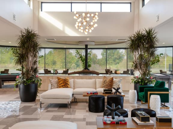 the lobby of a hotel with a couch and chairs and large windows at Esplanade District Apartments, Little Rock