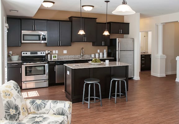 A kitchen with a black countertop and a white fridge.