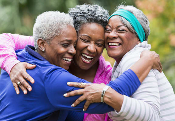 Three women hugging each other in a close embrace.