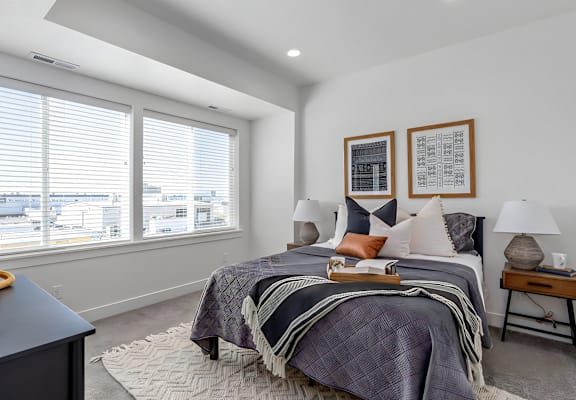 a bedroom with a bed and two windows