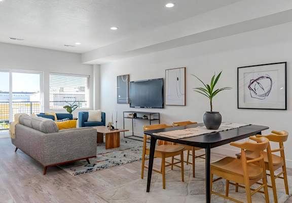 a living room and dining room with a table and chairs