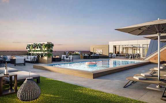 A modern outdoor pool area with lounge chairs and a hanging plant.