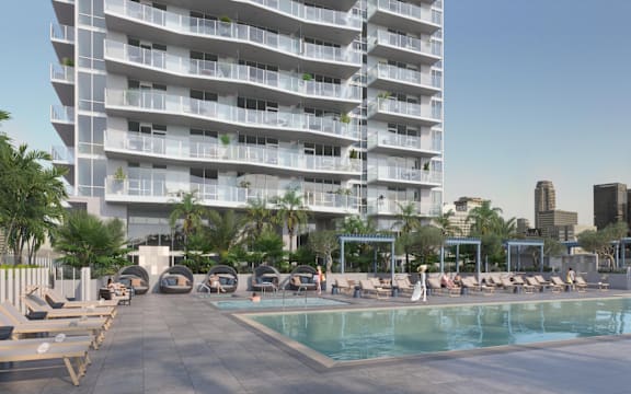 A large white building with a pool in front.