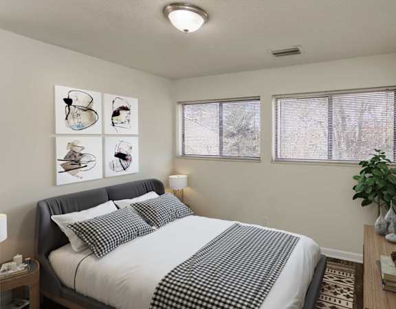 A bedroom with a bed, nightstand, and pictures on the wall.
