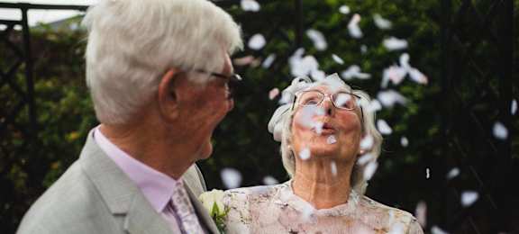 an older couple standing in front of a tree