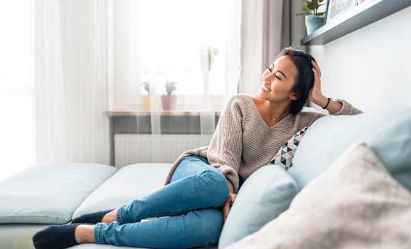 Woman sitting on a couch at Mainstreet Apartments, Clearwater, Florida 33756
