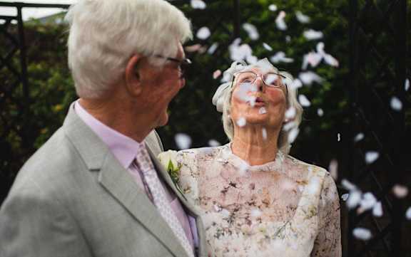 an older couple standing in front of a tree