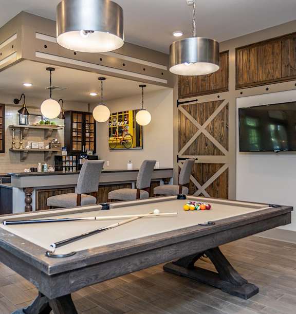 a games room with a pool table and a tv