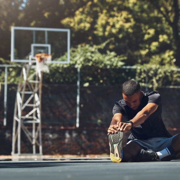 Man Stretching Before Playing Basketball