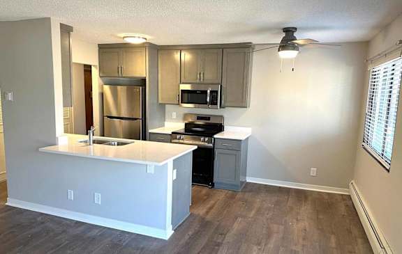 A kitchen with a white countertop and stainless steel appliances.