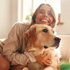 a woman and her dog laying on the grass