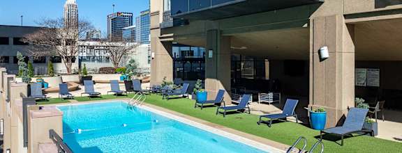 A swimming pool with a slide and lounge chairs.