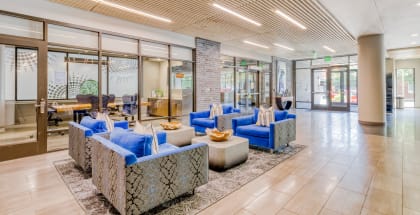a lobby with blue couches and chairs