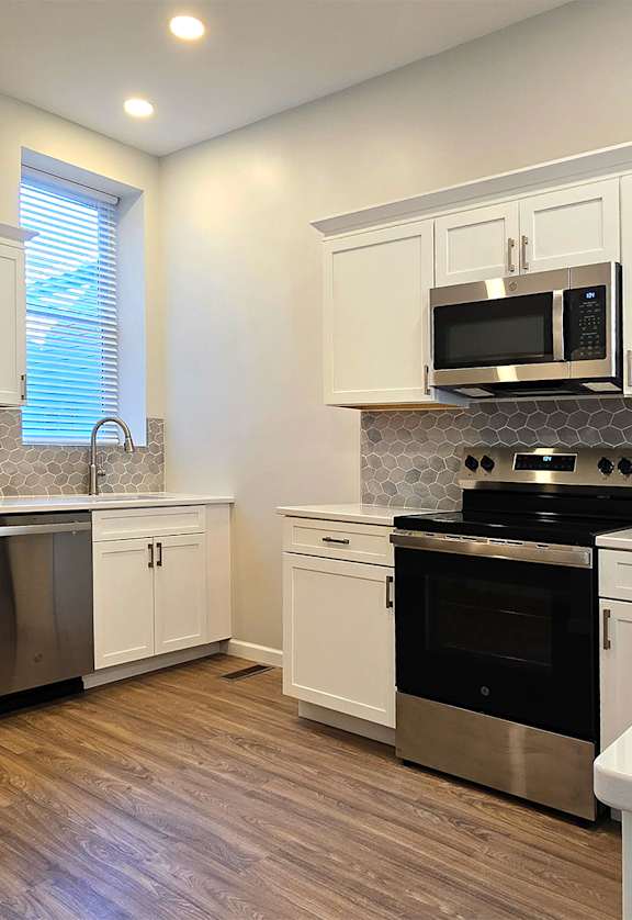 A modern kitchen with stainless steel appliances and white cabinets.