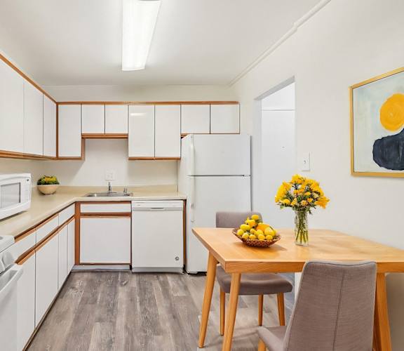 A kitchen with a white stove top oven and a white refrigerator.