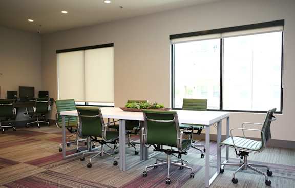 A conference room with a long table surrounded by chairs.